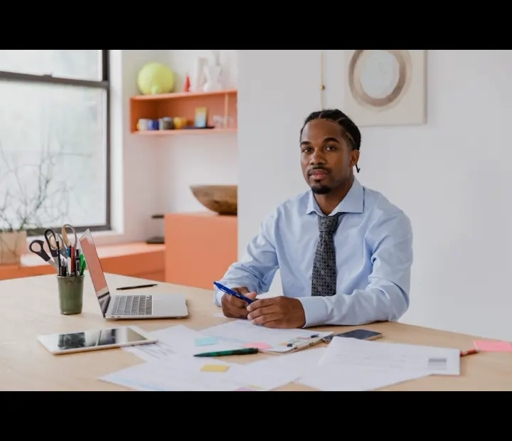 A 1099 contractor working at a laptop in a bright home office.