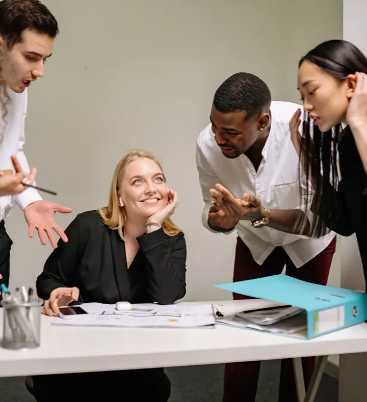 A group of colleagues in an animated discussion around a table.
