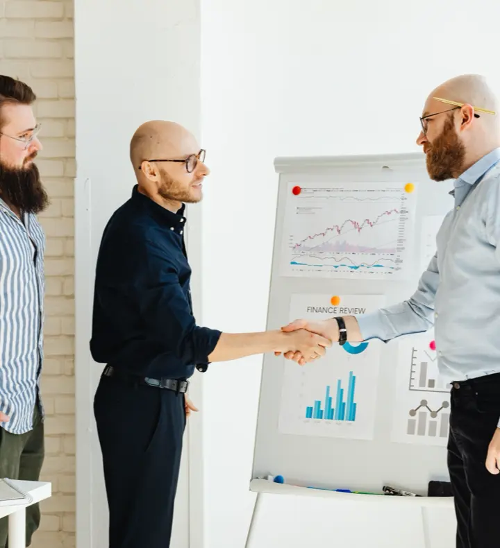 Three colleagues reviewing figures together in a working meeting.